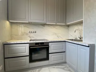 Маленькая угловая кухня с фрезерованными фасадами без ручек